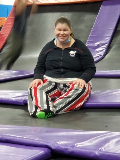 Girl Smiling Sitting on a Mat in a Trampoline Park